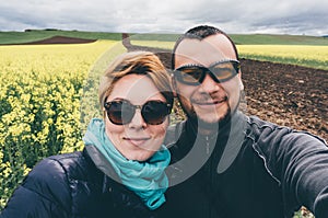 Couple taking selfie in canola field