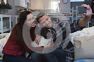 Couple taking selfie with mobile phone in living room