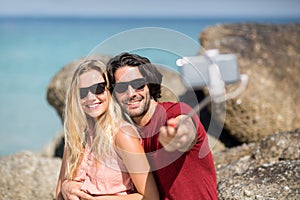 Couple taking selfie with monopod at beach