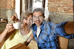 Couple taking selfie photo with mobile phone at coffee shop smiling happy in romance love concept