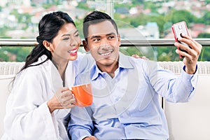 Couple taking selfie picture on balcony