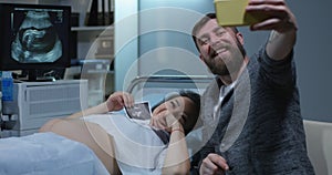 Couple taking a selfie in sonography cabinet