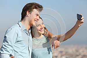 Couple taking selfies in a city outskirts photo