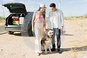 Couple taking their dog on a walk during a road trip