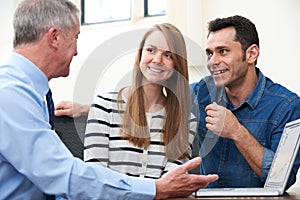 Couple Talking With Financial Advisor In Office