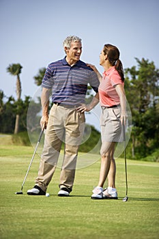 Couple talking on golf course