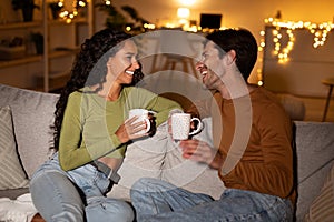 Couple Talking Laughing And Drinking Coffee Sitting At Home