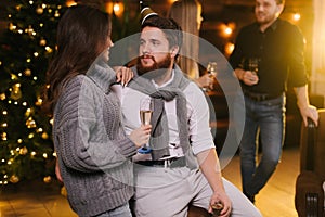 Couple talking on New Year Eve against backdrop of festive Christmas tree