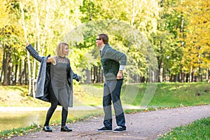 Couple talking seriously outdoors in a park with a green background