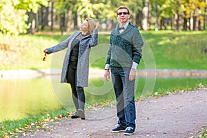Couple talking seriously outdoors in a park with a green background