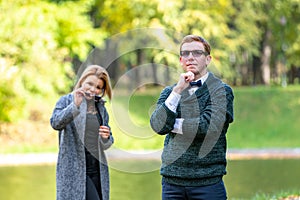 Couple talking seriously outdoors in a park with a green background