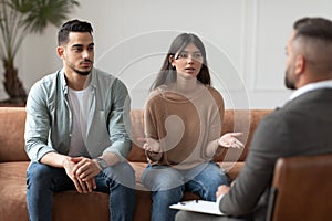 Couple talking at session with professional male therapist