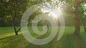 A couple on a tandem bike rides at sunset through the park between the trees