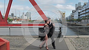 Couple of tango dancers doing coreography on a bridge over Puerto Madero docks