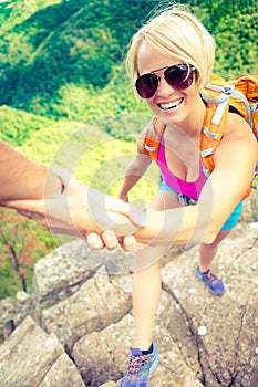 Couple teamwork, man and woman helping hand on hike