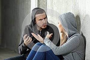 Couple of teenagers arguing in a dark place photo