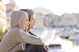 Couple of teens contemplating horizon in a coast town photo