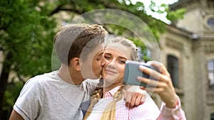 Couple of teens making selfie, boy kissing girl, photo for personal blog, love