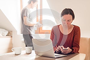 Couple telecommuting, woman and man working in home office photo