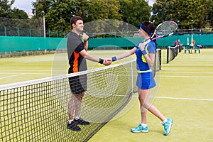 Couple of a tennis players shaking hands over the net