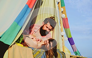 Couple in a tent. Young lovers hugging and embracing. Couple in love camping, tenderness and affection in nature.