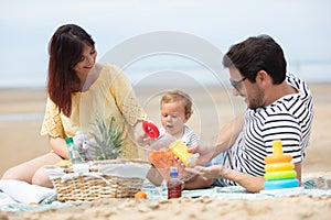 couple with their baby at sea on beach