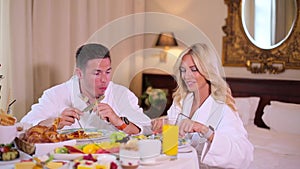 A couple in their bathrobes dines at the hotel