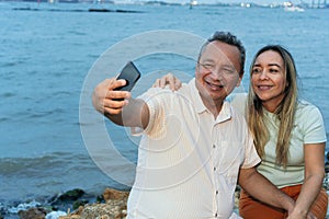 Couple in their fifties taking a selfie with their cell phone