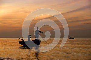 A couple on their fishing boat working in the morning