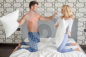 Couple in their sleepwear having a pillow fight