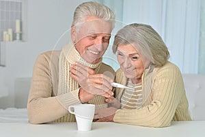 Couple with thermometer at home