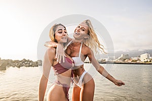 Couple of thin babes young woman blonde and brunette enjoy the summer vacation hugging and laughing together. playful