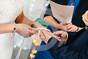 Couple tiding knot during wedding ceremony