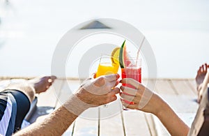 Couple toasting with cocktails by the pool