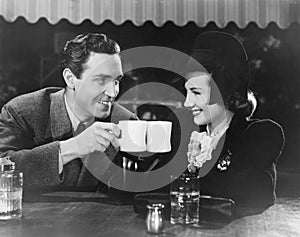 Couple toasting with mugs