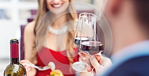 Couple toasting with red wine in romantic restaurant