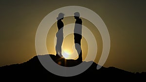 Couple on top of hill against sunset, fateful meeting on edge of earth, love