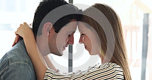 Couple touch their foreheads, smiling, cherishing closeness of their connection