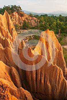Couple tourists at ancient scenic landscape at sunset. The Sao Din Na Noi site displays picturesque scenery of eroded sandstone