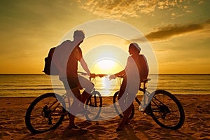 Couple tourists with Bicycles Watching Sunset. Silhouette people