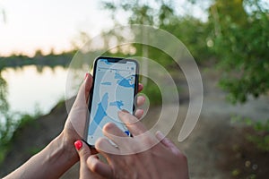 A couple of tourists on a camping trip, looking for the way by GPS on a smartphone. An application with a map of the