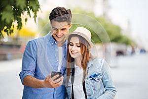 Couple of tourists consulting smartphone gps in the street searching locations in new city