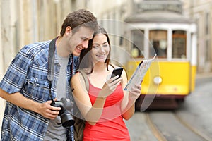 Couple of tourists consulting guide online photo
