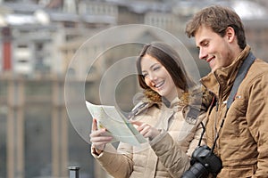 Couple of tourists consulting a guide in winter