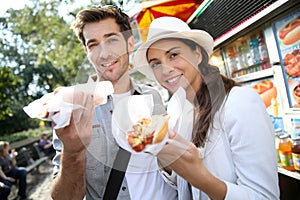 Couple of tourists eating fastfood on travel