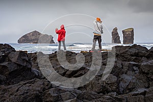 Couple of tourists photographing the Mosteiros Volcanic Beach