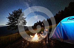 Couple tourists resting at night camping under stars