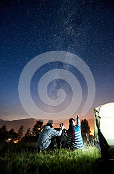 Couple tourists resting at night camping under stars