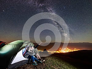 Couple tourists resting at night camping under stars