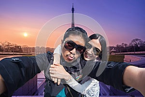 Couple Tourists selfie with mobile phone near the Eiffel tower in Paris, France